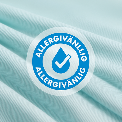 Allergivänligt kyltäcke från NordicBlankets – närbild på isblå textil med certifieringssymbol som bekräftar hypoallergena egenskaper